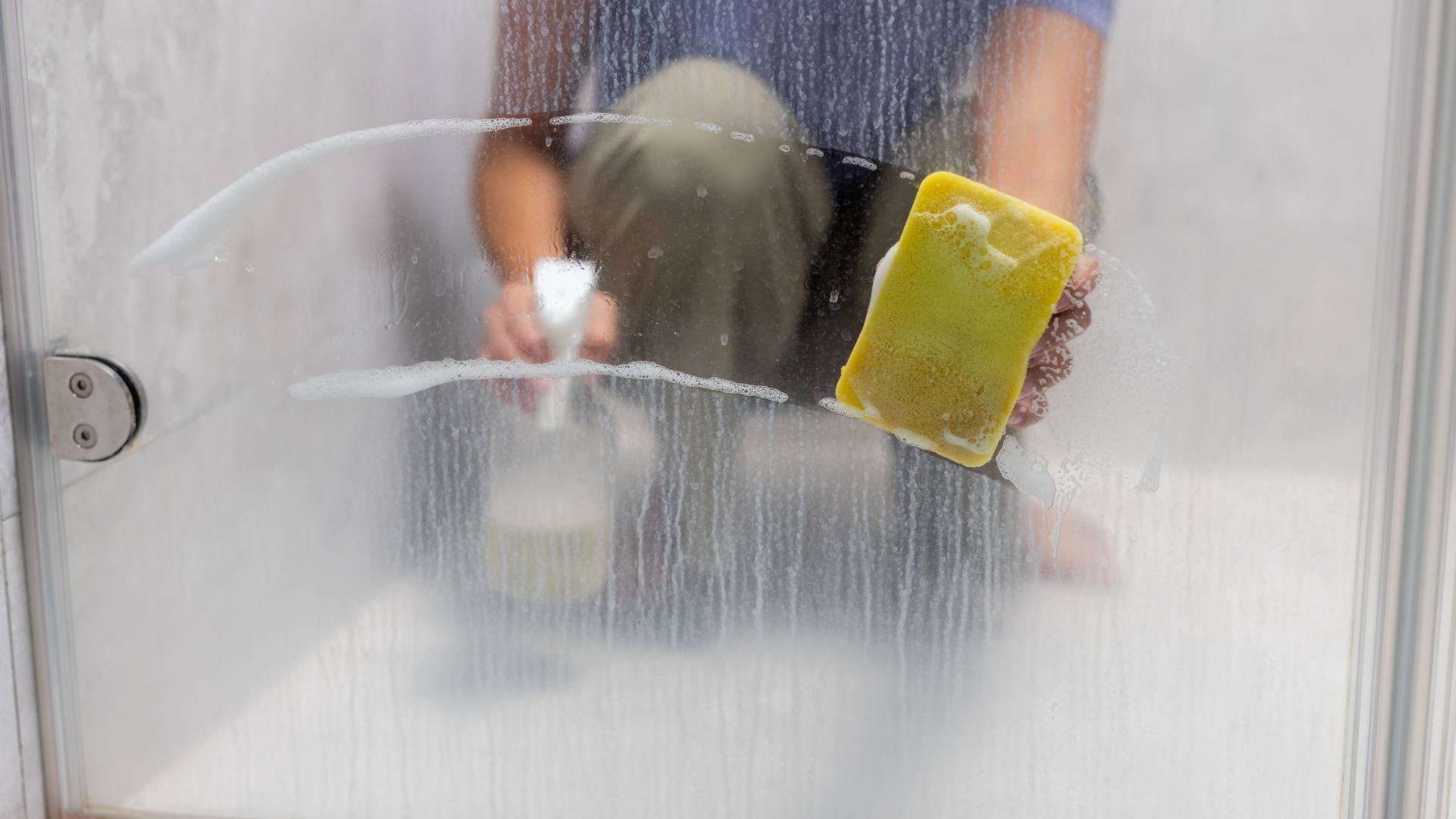 Whole house water softeners. A woman cleaning water spots off the shower.