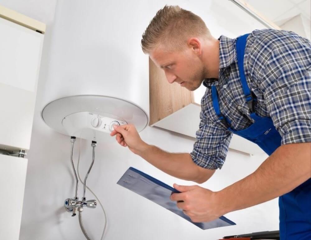 Plumber calibrating the water heater